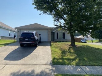 A black car is parked in front of a house with a tree to the right.