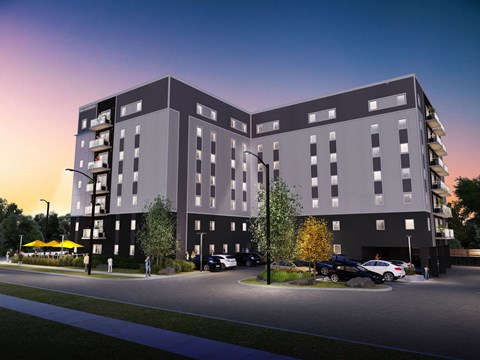 A modern apartment building with a parking lot in front.