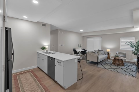 A modern kitchen with white cabinets and a refrigerator.
