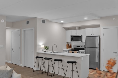 A modern kitchen with white cabinets and stainless steel appliances.