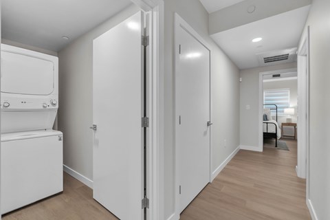 A white refrigerator is in a kitchen next to a white door.