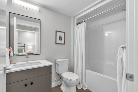 A bathroom with a toilet, sink, and shower.