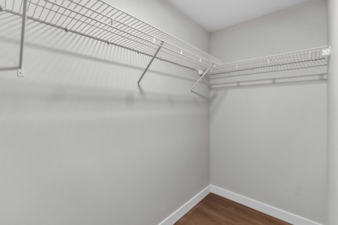 Empty room with a white wall and a wire shelf.