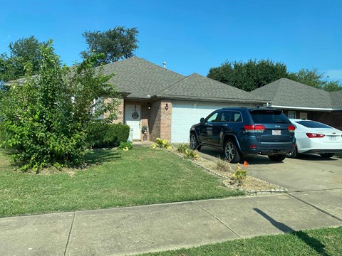 A black SUV is parked in front of a house.
