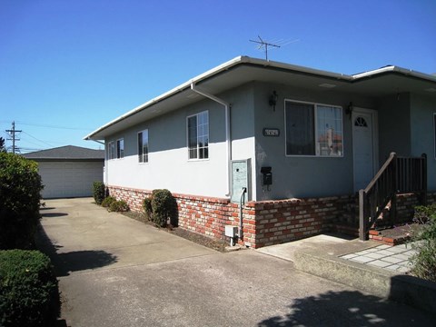 A house with a grey roof and a white garage door.