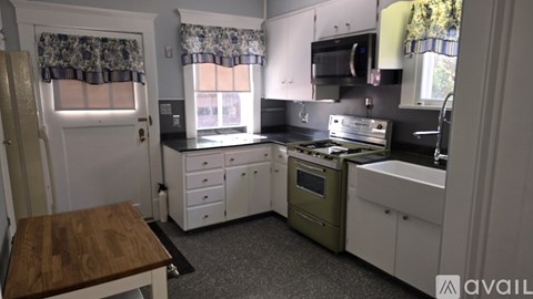 A kitchen with white cabinets and a wooden table.