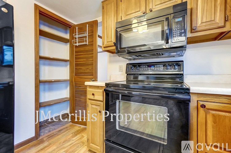 A kitchen with wooden cabinets and a black oven.
