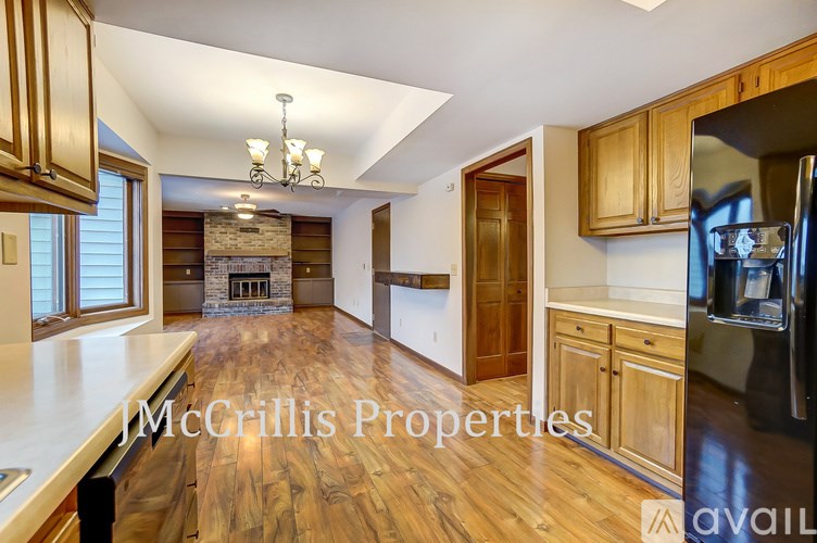 A kitchen with wooden cabinets and a stone fireplace.