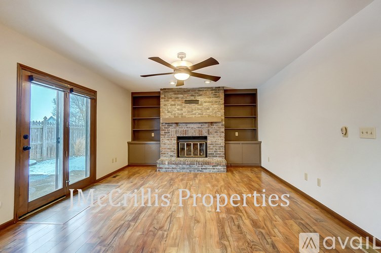 A spacious room with a fireplace and a ceiling fan.