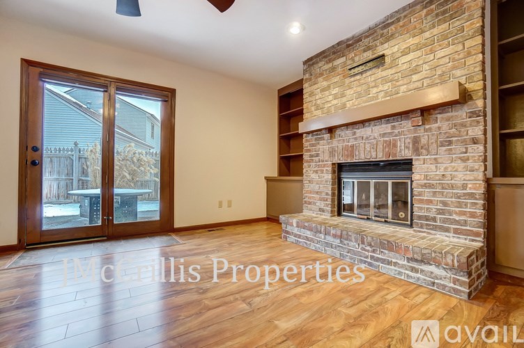 A McCollis Properties sign is on a wall above a fireplace in a living room.