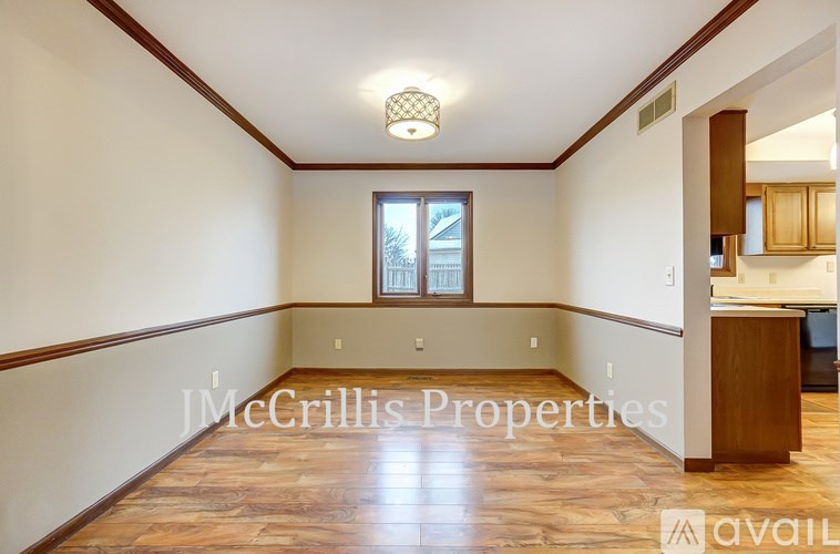 A spacious room with wooden floors and a window.