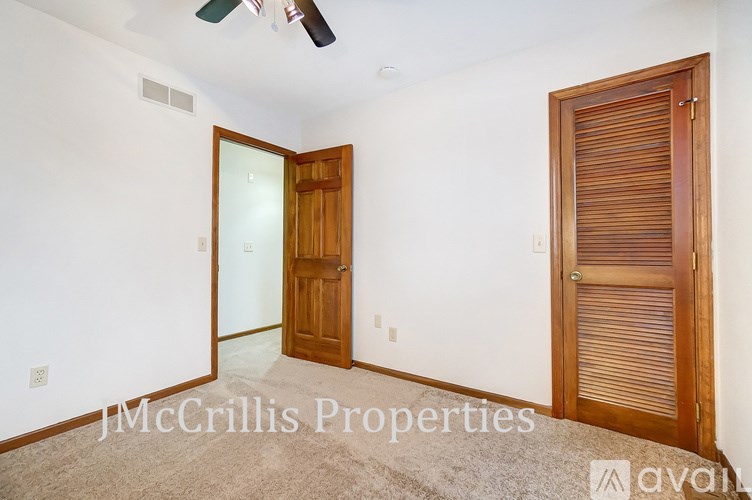 A room with a ceiling fan and two doors, one of which is closed.