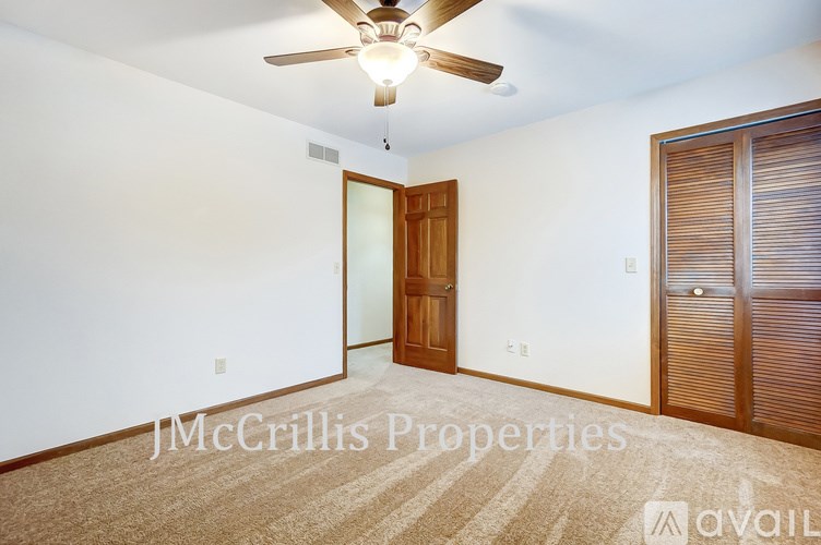 A room with a ceiling fan and a door with a window.