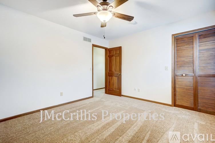 A room with a ceiling fan and a carpeted floor.