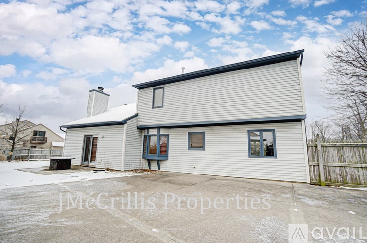 A house with a white exterior and a brown roof is for sale.