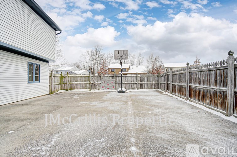 A snowy yard with a fence and a sign that says "JMcGillis Property".
