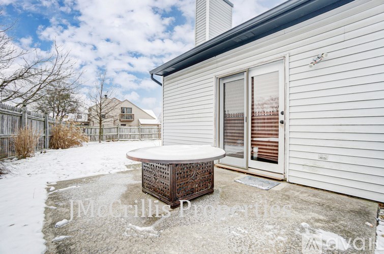 A white house with a snow-covered ground and a table in front.