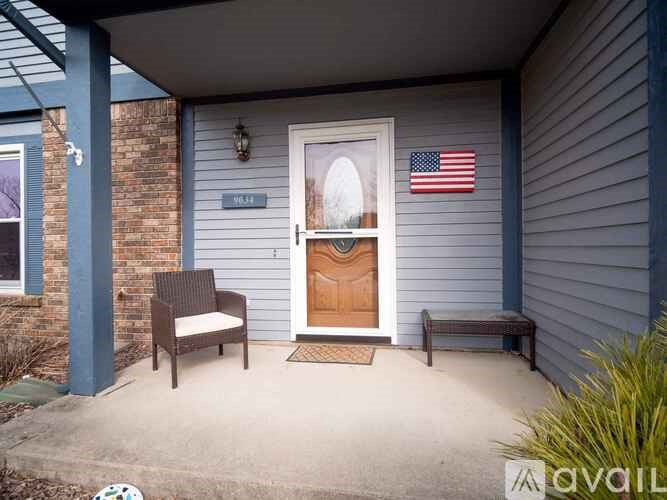 A house numbered 1643 has a porch with a bench and a chair.