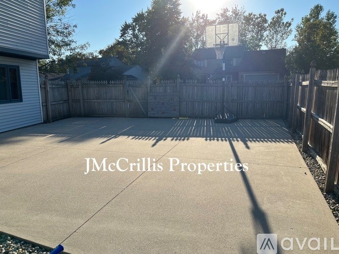 A backyard with a basketball hoop and a fence.