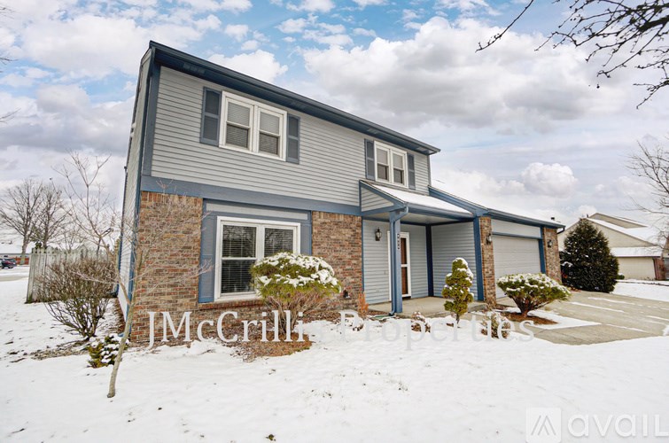 A house with a grey roof and a sign that says "JMcCrill".