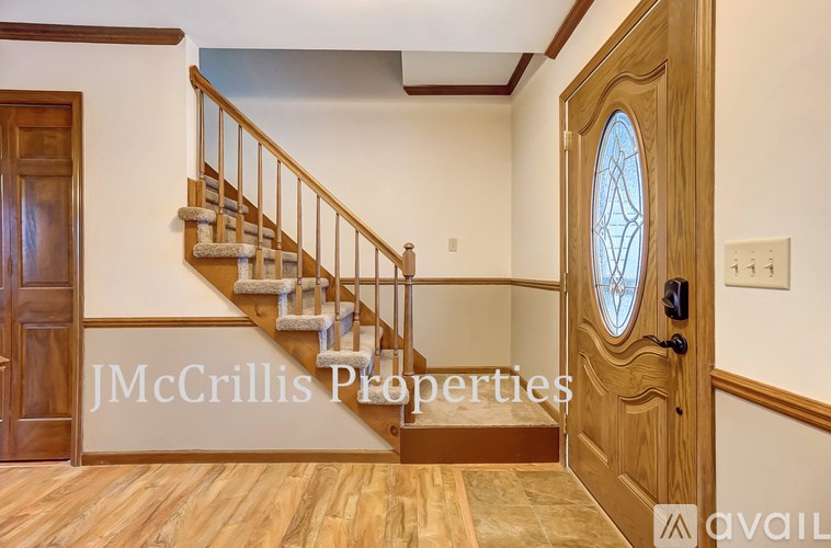 A wooden staircase with a glass door and a window.