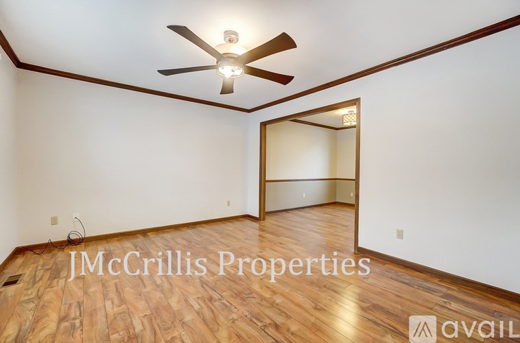 A room with wooden flooring and a ceiling fan.
