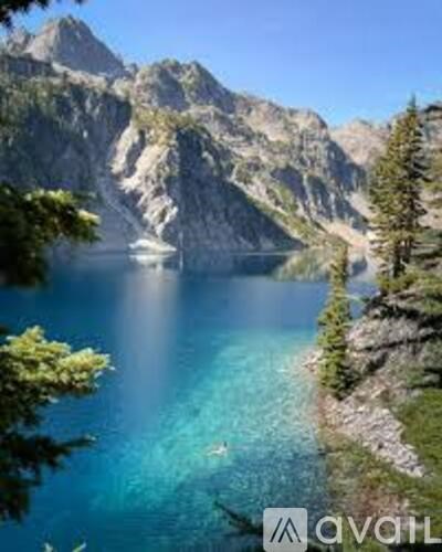 A boat is sailing in a lake surrounded by mountains.