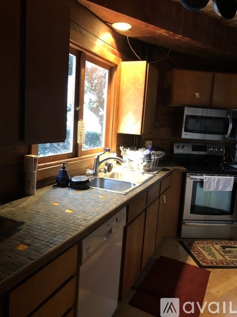 A kitchen with wooden cabinets and a tiled countertop.