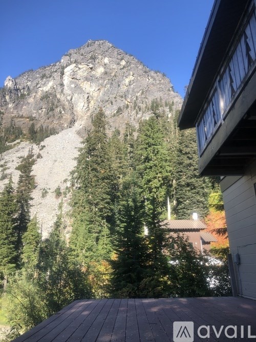A mountain with a house in the foreground.