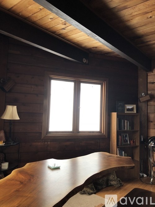 A room with wooden walls and a large window.