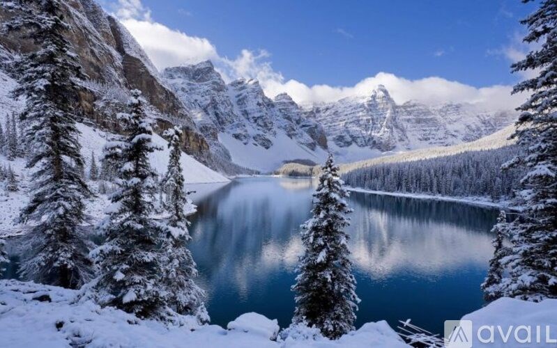 A lake surrounded by snowy trees and mountains.