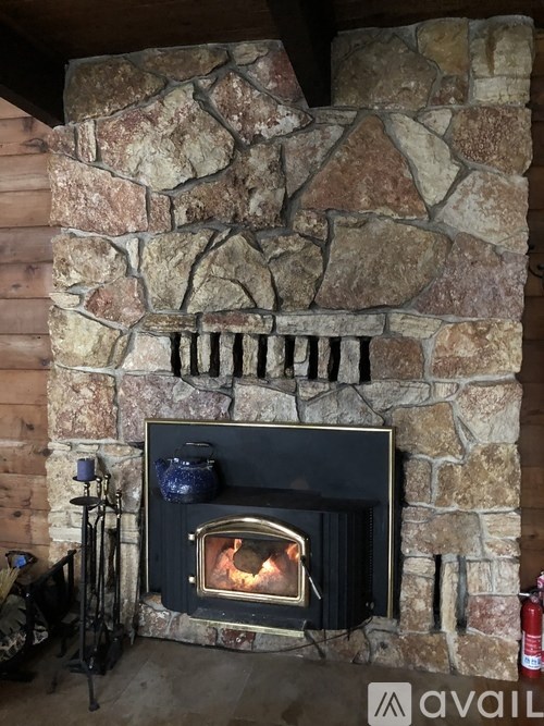 A stone fireplace with a fire burning inside.