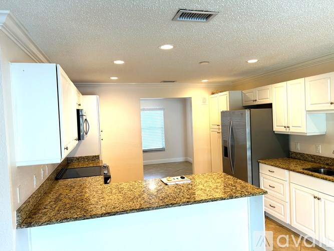 A kitchen with granite countertops and white cabinets.