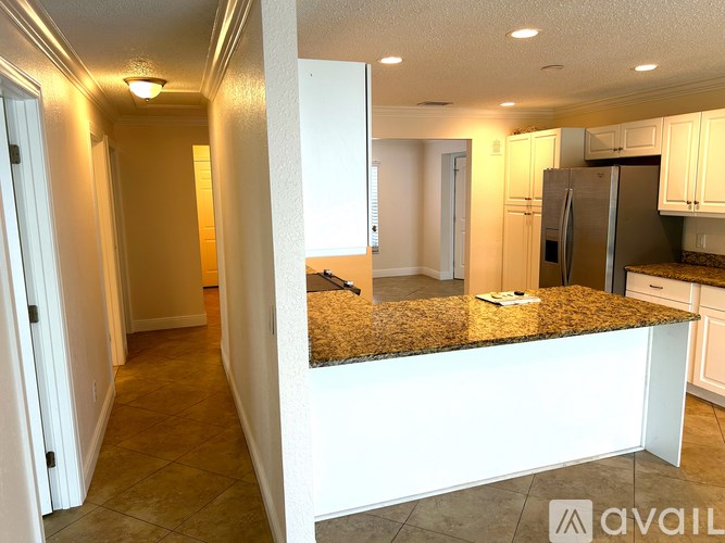 A kitchen with granite countertops and white cabinets.