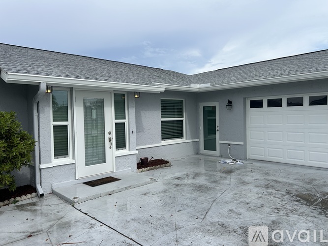 A house with a grey roof and a white garage door.