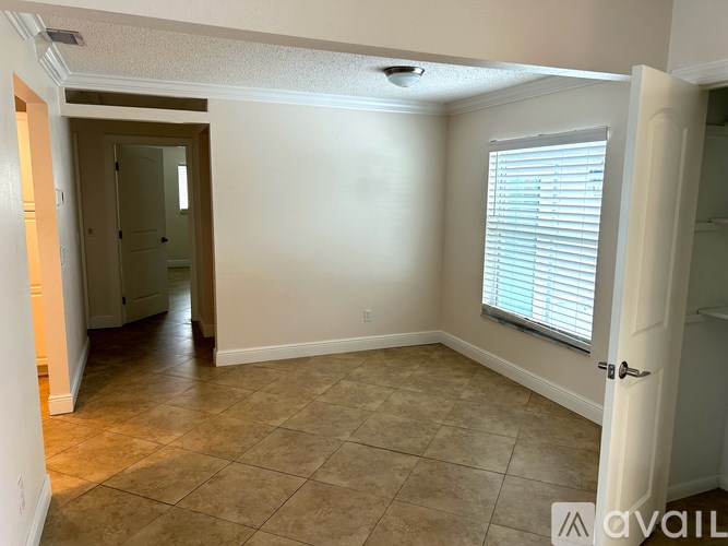 A room with a tile floor and a window with blinds.