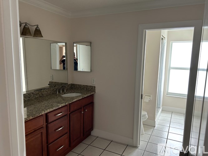 A bathroom with a sink, mirror, and cabinets.