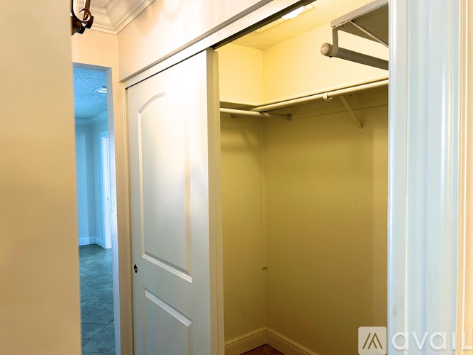 A white door is open to a small, empty room.