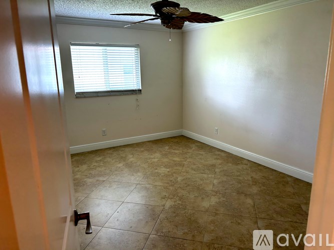 A room with a fan and a window.