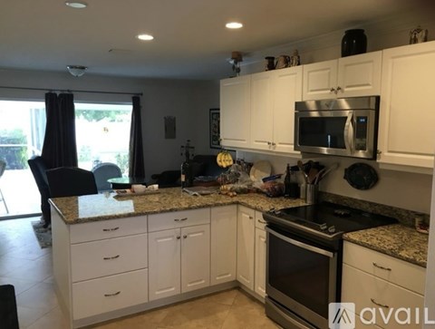 A kitchen with white cabinets and granite countertops.
