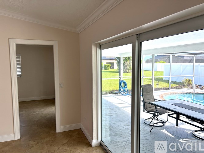 A room with a sliding glass door leading to a pool area.