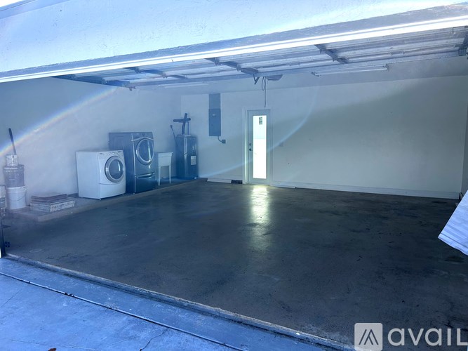 A large garage with a white ceiling and a door on the right side.