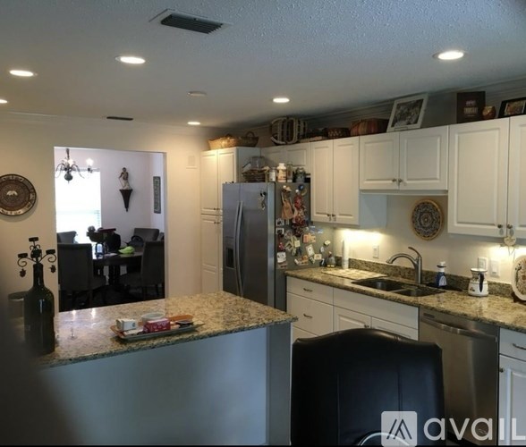 A kitchen with a granite countertop and a refrigerator.