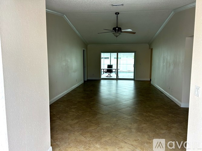 A house with a grey roof and a white wall with a glass door and window.