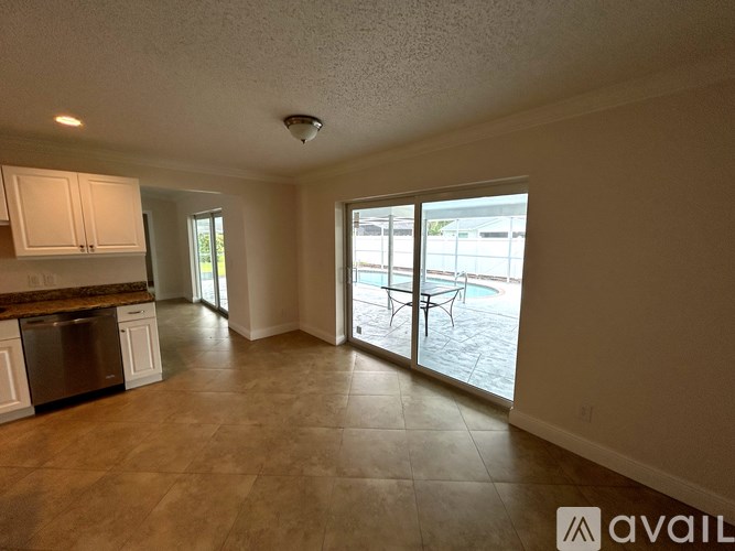A kitchen with a dining table and chairs is visible through the sliding glass doors.