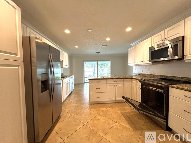 A kitchen with a refrigerator, microwave, and oven.