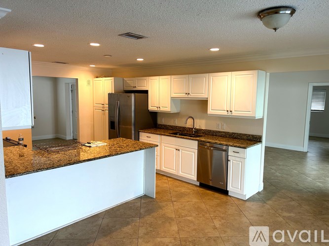 A kitchen with granite countertops and white cabinets is available for rent.