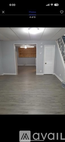 A room with wooden flooring and a white door.