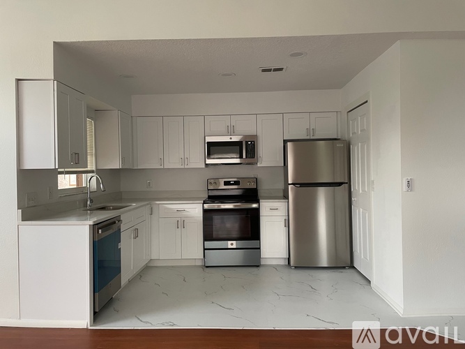 A modern kitchen with stainless steel appliances and white cabinets.