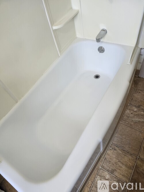 A room with wooden flooring and a wall socket.